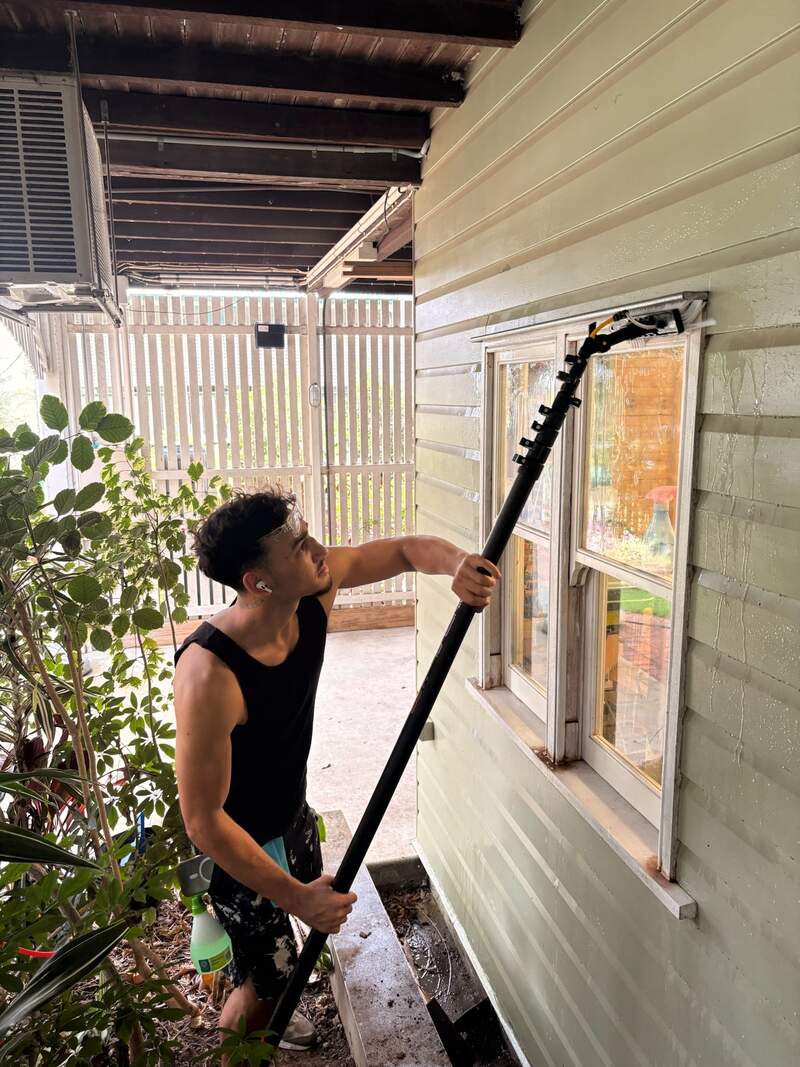 Home Boost team member cleaning a window with a water-fed pole